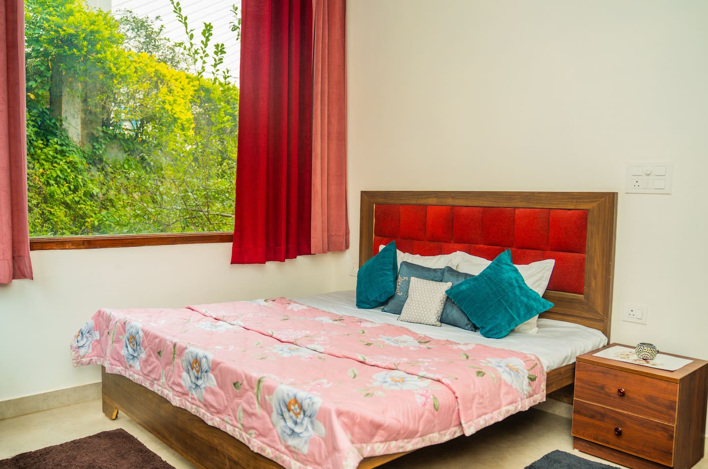 First floor bedroom with pastel bedding and forest view window
