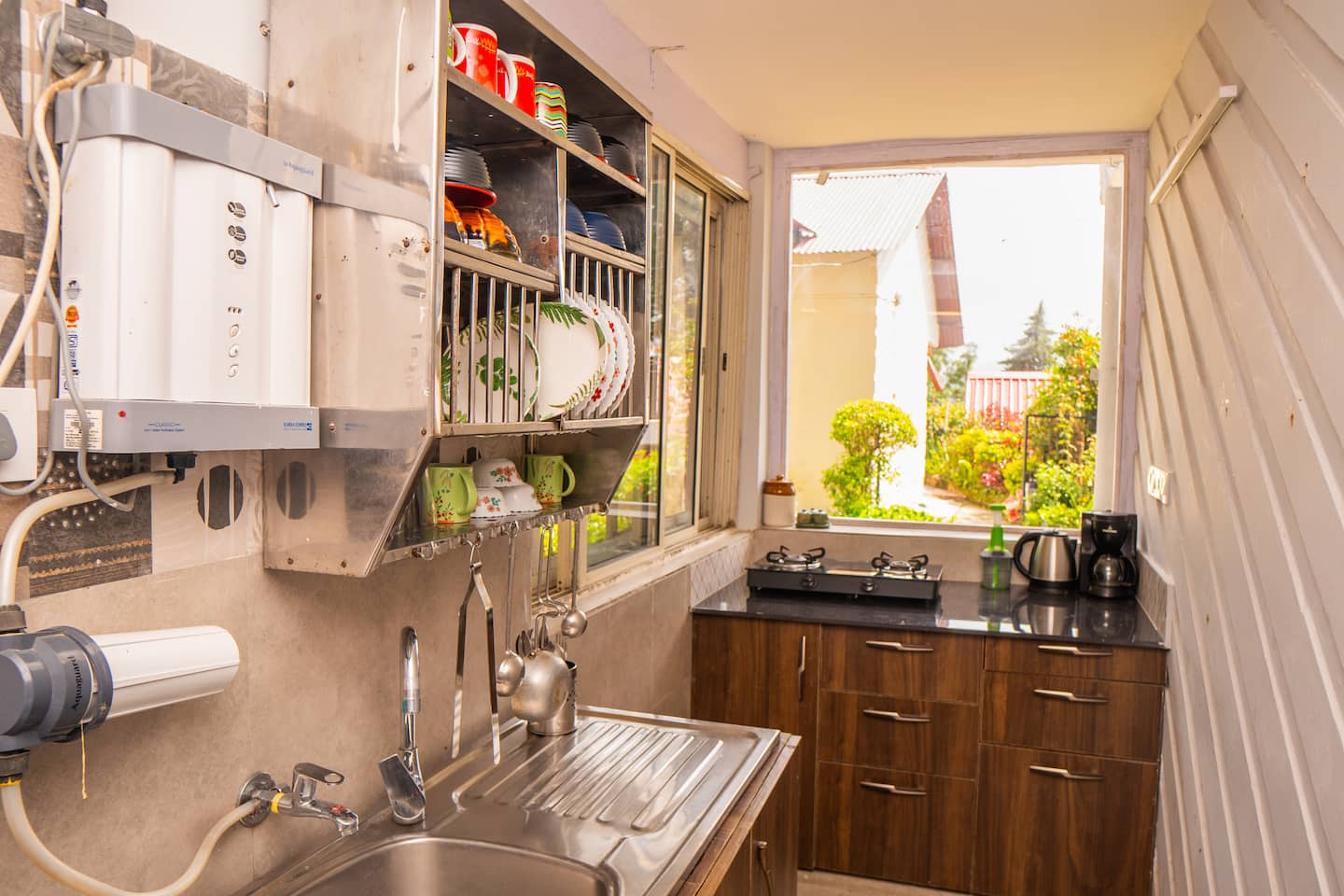 Clean vegetarian kitchen with steel sink and open shelves
