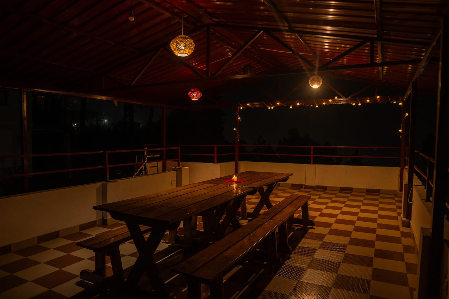 Rooftop deck lit with fairy lights and lanterns after dark